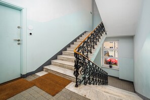 A staircase with a handrail, a doormat, and a door. - Apartamenty Sun & Snow Chmielna (Warszawa)
