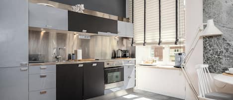 A modern kitchen with stainless steel appliances, a built-in oven, and a coffee machine.