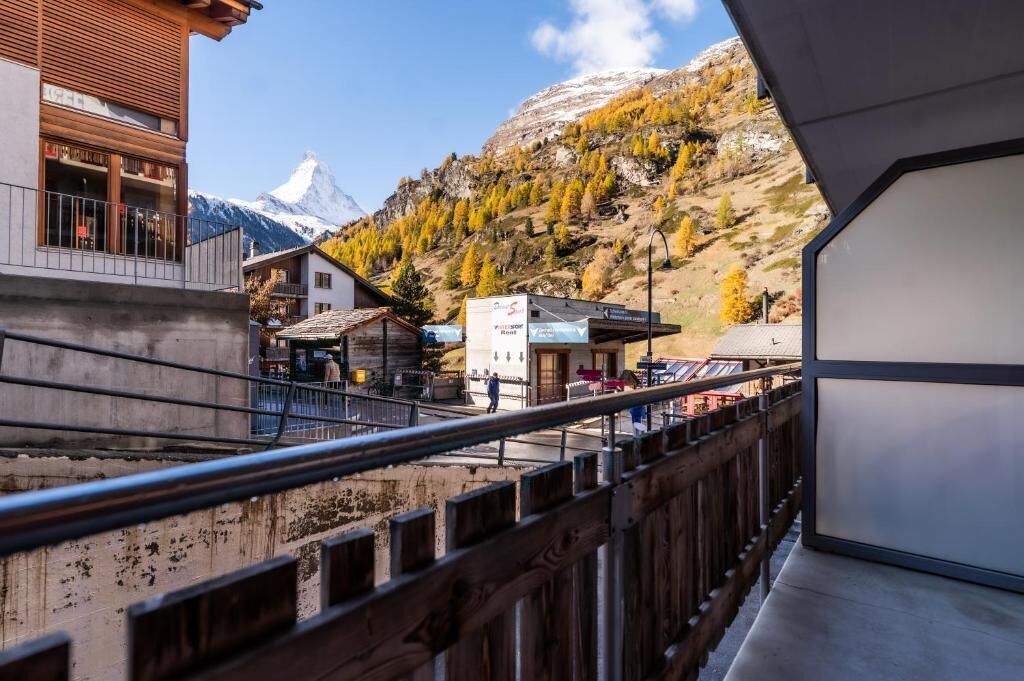 A mountain view with a building and a sign indicating a restaurant.