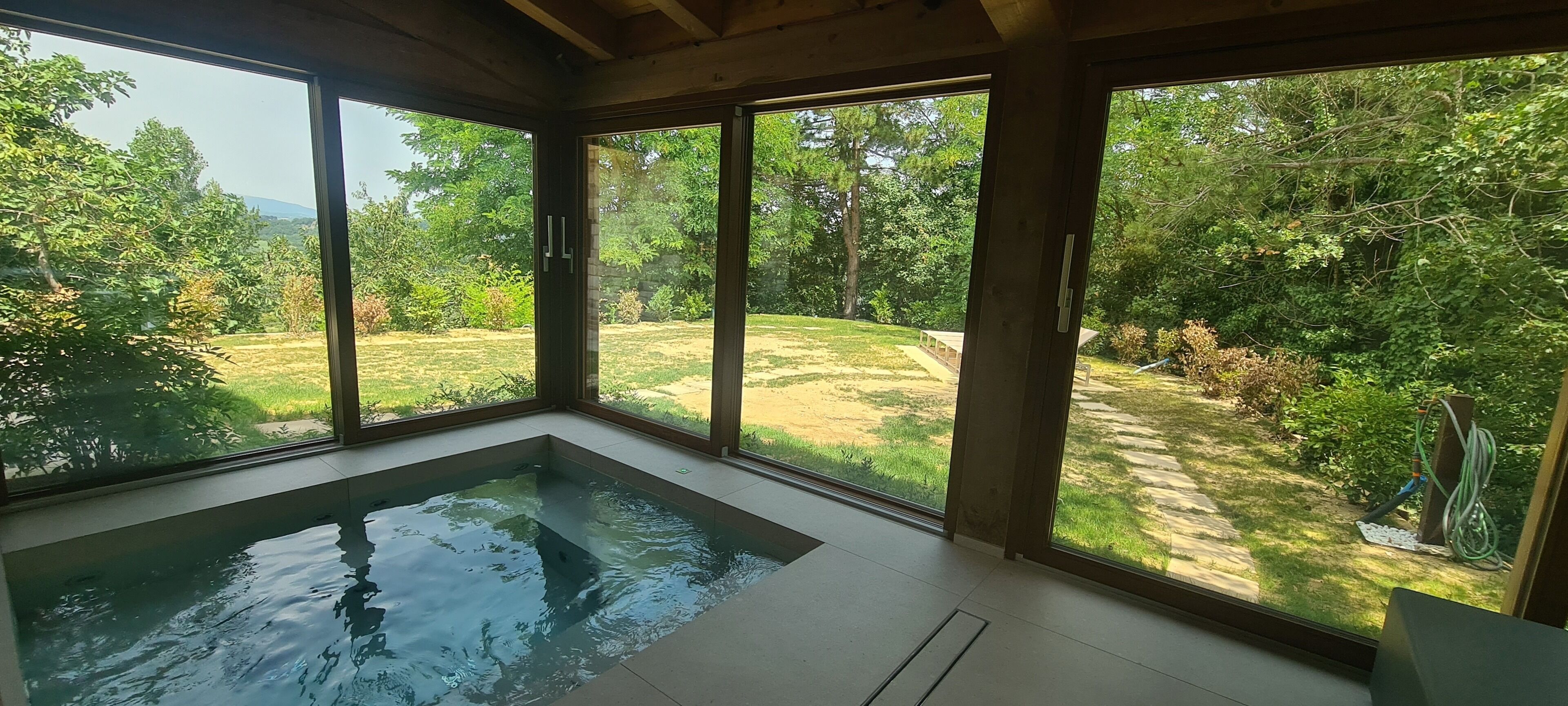 A room with a large glass window and a built-in hot tub.