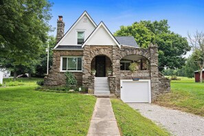 A two-story house with a stone facade, a front entrance with steps, and a garage. - 3BR Stone Farm House, Parking, Grill, Laundry (Florence)