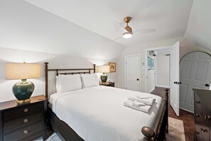 A neatly made bed with white linens, a wooden headboard, and a bedside table with a lamp. - 3BR Stone Farm House, Parking, Grill, Laundry (Florence)