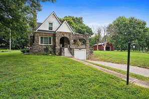 A two-story house with a stone facade and a garage. - 3BR Stone Farm House, Parking, Grill, Laundry (Florence)