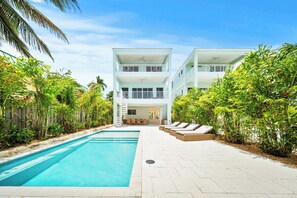 A two-story building with a swimming pool and outdoor seating area. - Luxury 5BD/6BTH+ Bonus cabana room|Pool|Dockage X2 (Marathon)