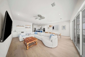 A modern living room with a sectional sofa, a wooden coffee table, and a flat-screen TV. - Luxury 5BD/6BTH+ Bonus cabana room|Pool|Dockage X2 (Marathon)