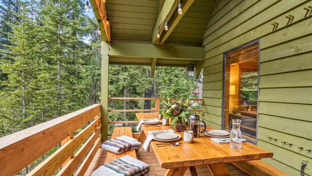 A wooden deck with picnic tables and benches, surrounded by a forest. - Govy 4BR•Ski-In/Out•Hot Tub•2 Living Rooms (Government Camp)