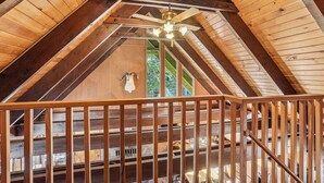 A wooden interior with a sloped ceiling, a mounted animal head, and a view of the outdoors through windows. - Govy 4BR•Ski-In/Out•Hot Tub•2 Living Rooms (Government Camp)