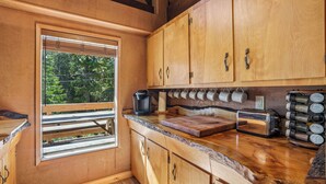 A wooden kitchen with a built-in window, wooden cabinets, a coffee maker, a toaster, and spice jars. - Govy 4BR•Ski-In/Out•Hot Tub•2 Living Rooms (Government Camp)