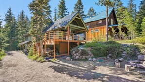 A cabin with a wooden deck, a covered porch, and a stone wall. - Govy 4BR•Ski-In/Out•Hot Tub•2 Living Rooms (Government Camp)