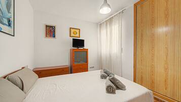 Tabla de planchar con plancha y ropa de cama