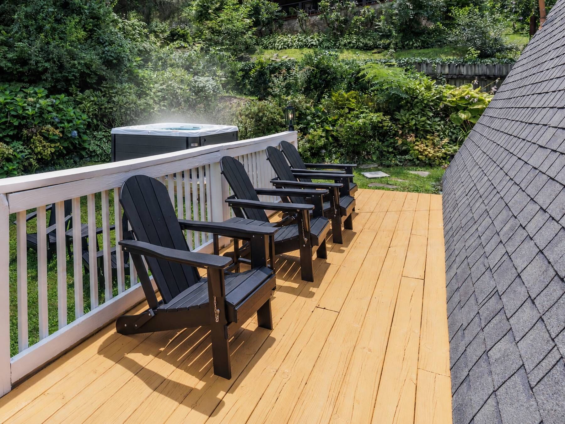 Een terras met zitplaatsen buiten en een hottub.