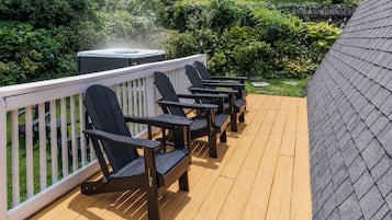 Een terras met zitplaatsen buiten en een hottub.