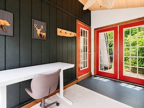 A room with a white desk, a gray chair, a red door, and a black wall with a deer picture. - Fontana Hideout - Mtn Views | Hot Tub | Tail of the Dragon | Fontana Village Amenities (Fontana Dam)