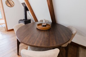 A round wooden dining table with a tray in the center, surrounded by chairs. - Fontana Hideout - Mtn Views | Hot Tub | Tail of the Dragon | Fontana Village Amenities (Fontana Dam)