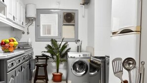 A compact kitchen with a washing machine, a sink, and a fruit bowl. - Central luxury apartment 3 bedrooms (Cairo Governorate)