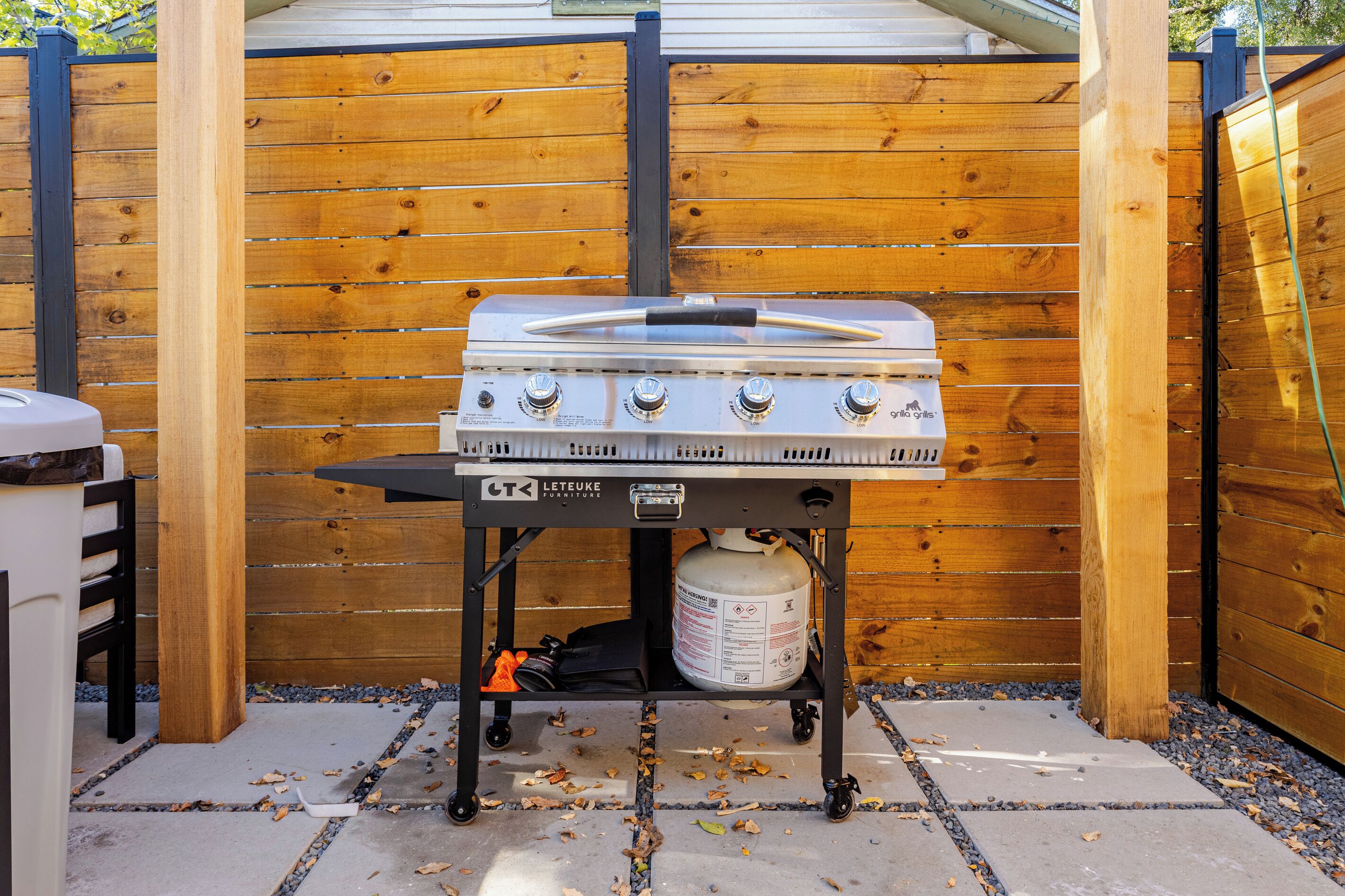 Un barbecue extérieur comprenant une bouteille de gaz, des boutons de réglage et un couteau posé sur le dessus.