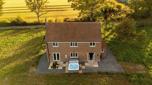 Ein zweistöckiges Haus mit Terrasse, Whirlpool und Ziegelaußenwand.