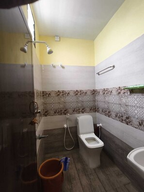 A bathroom with a shower, toilet, and bidet.