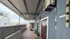 A covered balcony with a view of the city, a door, and potted plants. - Pet friendly cozy 1 BH for couples/families/groups (Coimbatore)