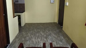 A room with a kitchenette, two wooden chairs, and a light-colored floor. - Pet friendly cozy 1 BH for couples/families/groups (Coimbatore)
