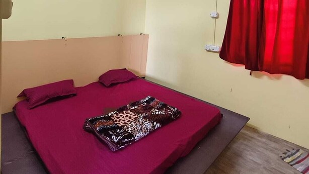 A bedroom with a bed, a ceiling fan, and a window with red curtains. - Pet friendly cozy 1 BH for couples/families/groups (Coimbatore)