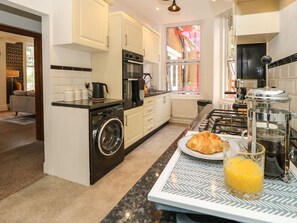 A modern kitchen with a built-in washer, oven, and stove. - The Pines (Bournemouth)
