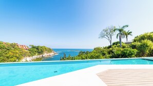 A swimming pool with a view of the ocean and greenery. - 2nd Level 2BR | Oceanview & Beach Access (Huatulco)