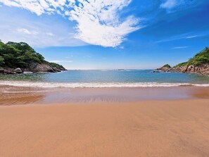 Ein Strand mit klarem Himmel und ruhigem Wasser.