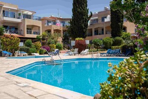 Ein Swimmingpool mit Liegestühlen und blauem Himmel.