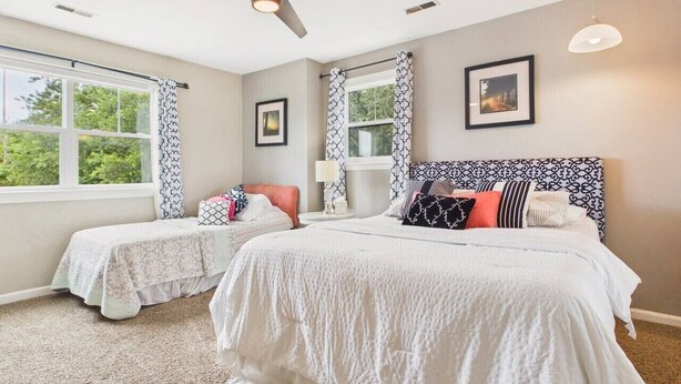 A bedroom with two beds, a ceiling fan, and a window with curtains. - `The Harlow`- The Cottage Collection (Virginia Beach)