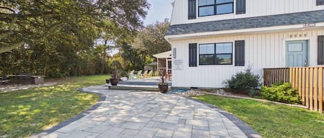 A pathway leading to a building with a star-shaped decoration on the facade, a sign indicating a business, and a well-maintained lawn.