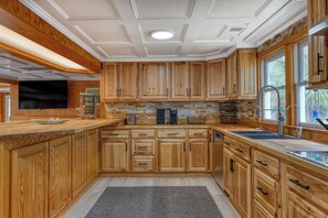 Eine Küche mit Holzschränken, einer Steinrückwand und einem eingebauten Geschirrspüler.
