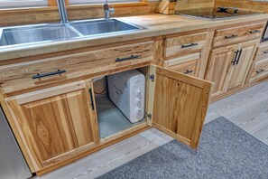 A kitchen with wooden cabinets, a double sink, and a built-in dishwasher. - Luna May - Charming 2 Bedroom, 3 Bath Beach House (Garden City Beach)