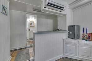 Eine Küche mit weißen Schränken, einem eingebauten Herd und einem grauen Kühlschrank.