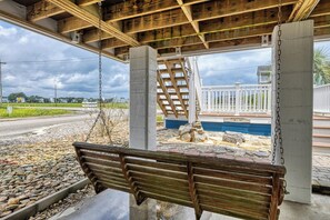 A concrete bench under a wooden structure with a view of a residential area and a swimming pool. - Luna May - Charming 2 Bedroom, 3 Bath Beach House (Garden City Beach)