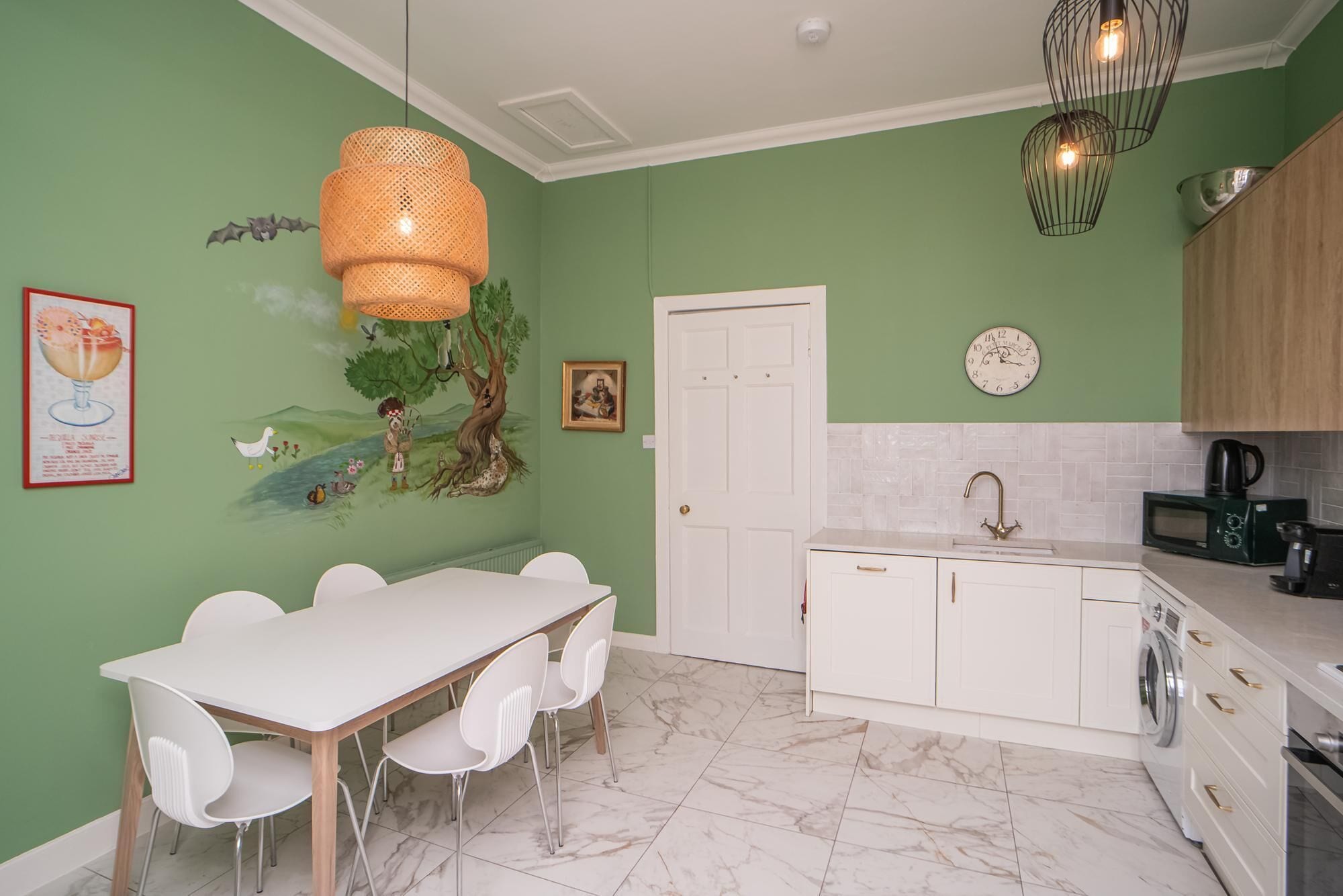 A kitchen with white cabinets, a sink, and a microwave.