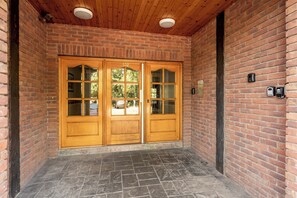 Un bâtiment en briques avec une porte en bois et un sol en pierre.