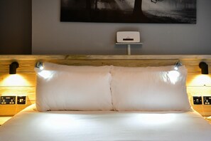 A bed with two pillows and a wall-mounted control panel. - Charming Apartment in the Heart of Llandaff - Pass the Keys (Cardiff)