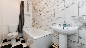 A bathroom with a toilet, a bathtub, and a sink. - Spacious Cardiff Apartment | WiFi | Near City - Pass the Keys (Cardiff)