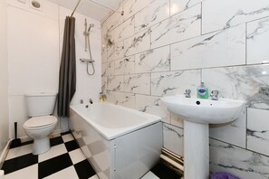 A bathroom with a toilet, a bathtub, and a sink. - Spacious Cardiff Apartment | WiFi | Near City - Pass the Keys (Cardiff)