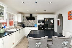 A modern kitchen with white cabinets, a black countertop, and a built-in oven. - Spacious Family Home | Free Parking | Sleeps 6 - Pass the Keys (Cardiff)