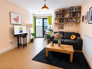 Ein modernes Wohnzimmer mit Sofa, Couchtisch und Bücherregal.