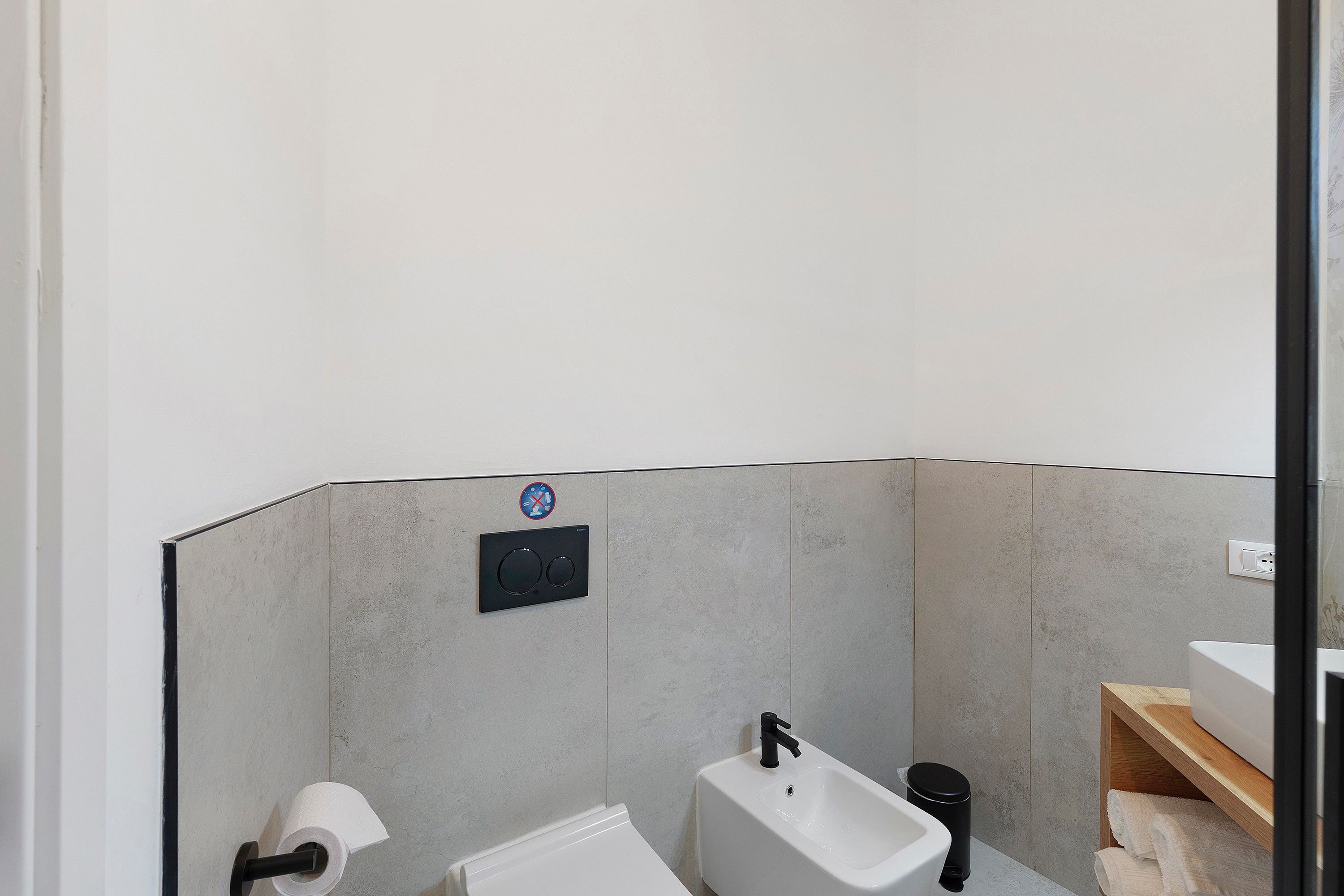 Ein modernes Badezimmer mit Toilette, Bidet und Waschbecken.