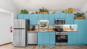 A kitchen with teal cabinets, stainless steel appliances, and a window above the sink. - Lake of the Ozarks Villa — Pool, Dock & Minutes to Shopping (Osage Beach)
