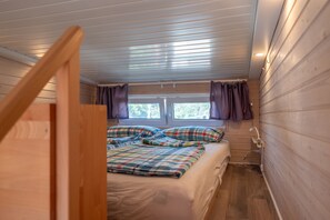 A bedroom with a bed, wooden walls, a window, and a ceiling fan. - Tiny Home “Tinyhaus Adelheid am Silbersee” (Freiburg im Breisgau)