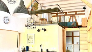 A compact kitchen with a built-in oven, a sink, and a dining area with a table and chairs.