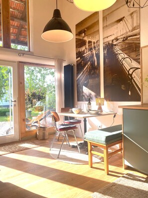A dining area with a table, chairs, and a large window.