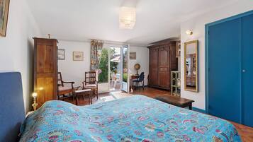 A bedroom with a bed, a wardrobe, a desk, and a chair.