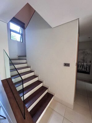 Un escalier moderne avec des rampes en verre et des marches en bois.