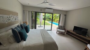 Une chambre d’hôtel avec un lit, une télévision et une vue sur une piscine.